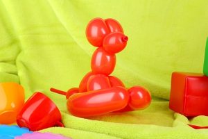 Dog balloon sculpting in red by balloon artist in Singapore
