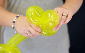 balloon artist sculpting a yellow flower