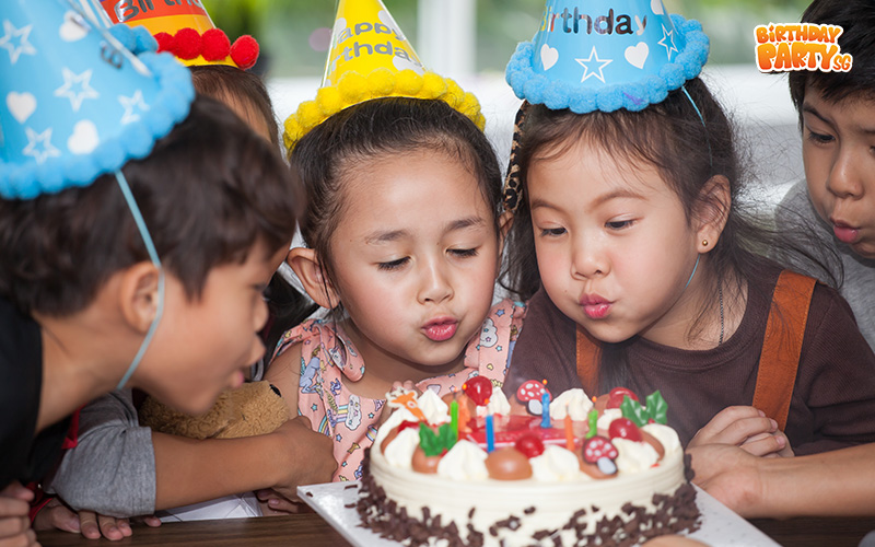 Children blowing out birthday candles in Singapore